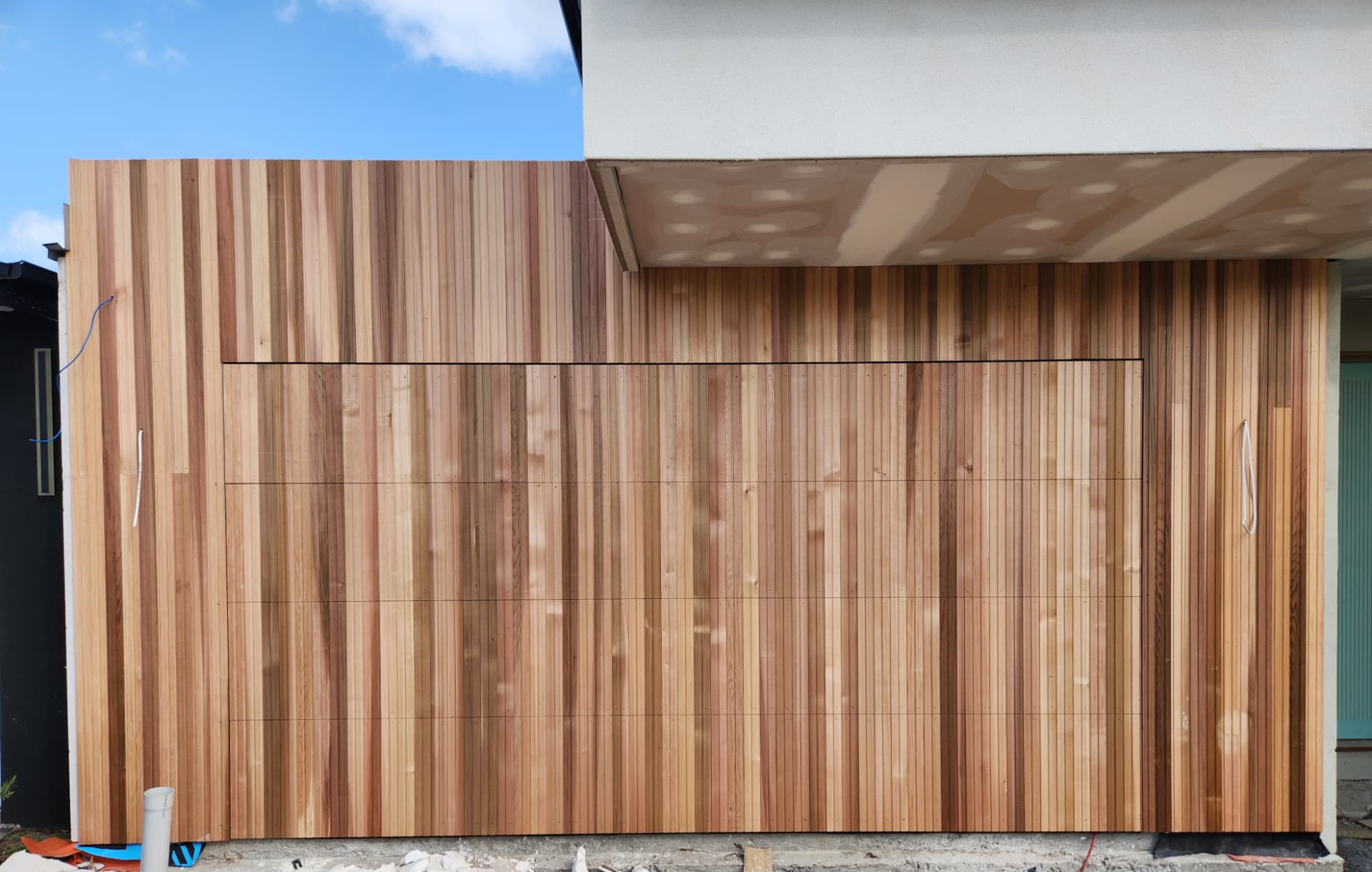 Vertical cedar cladding wrapping a garage facade